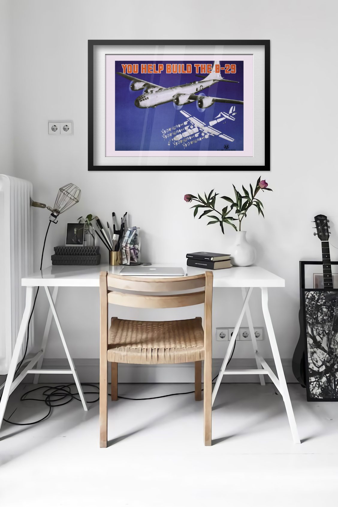You Help Build the B-29 poster framed above a desk in a bright white room