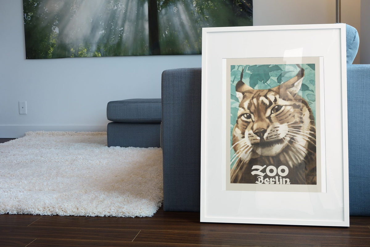 Zoo Berlin Lynx poster leaning beside a blue sofa